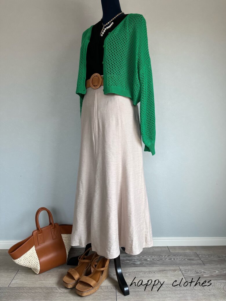 キャメルのかごバッグとグリーンのカーディガンとベージュのスカート
